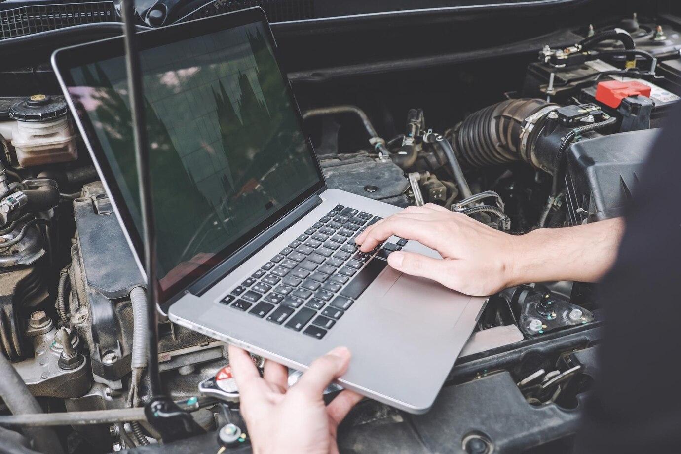 high-angle-view-man-holding-laptop-engine-car_1048944-30838925-transformed